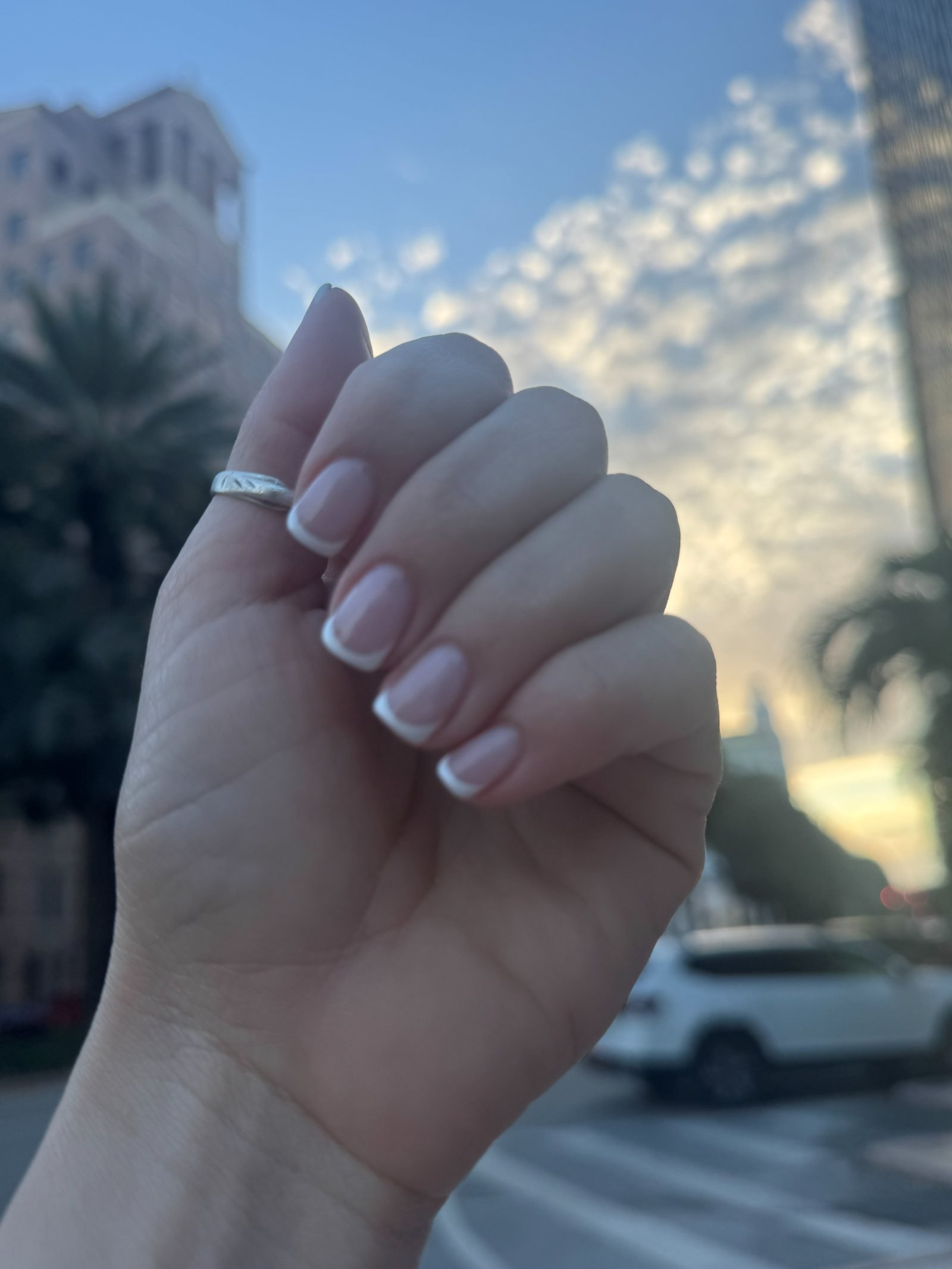 French tip gel manicure on almond nails, photographed outdoors in Coral Gables